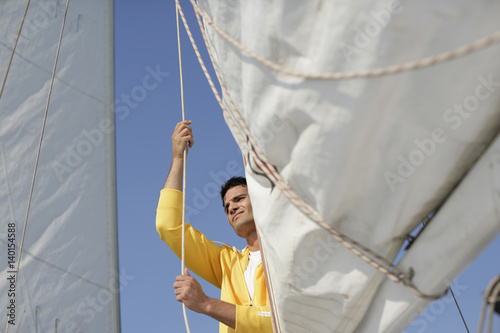 Man hoisting a sail