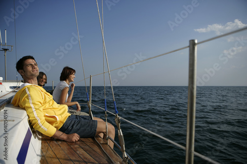 Two men and a woman sitting on sailboat border