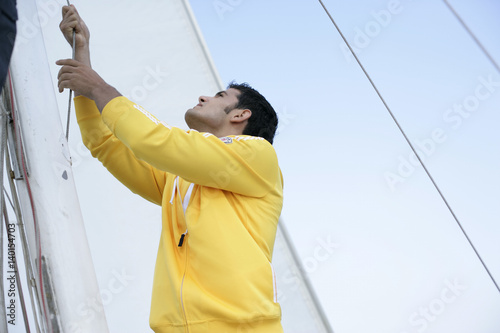 Fotografía Man hoisting a sail
