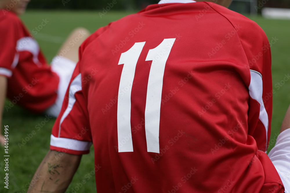 Fototapeta premium Soccer player wears number 11 sitting on grass