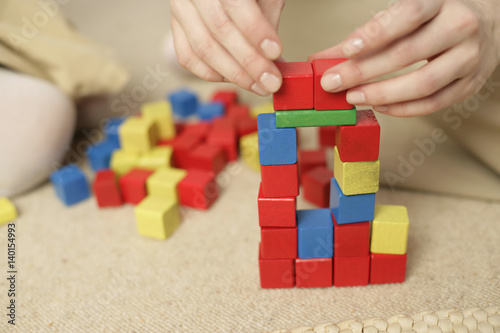 Woman stacking blocks, focus on hands