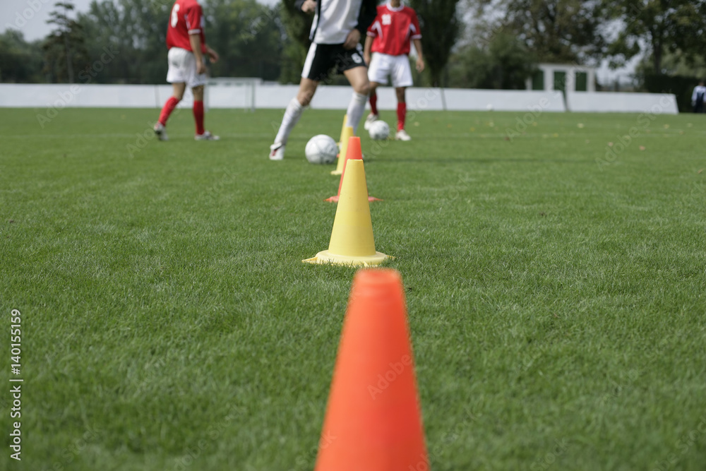 Obraz premium Soccer player running slalom with a football around marks