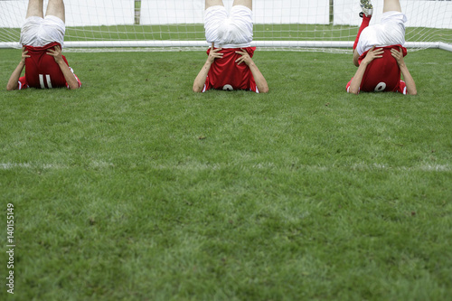 Soccer players doing stretching exercise in front of the goal