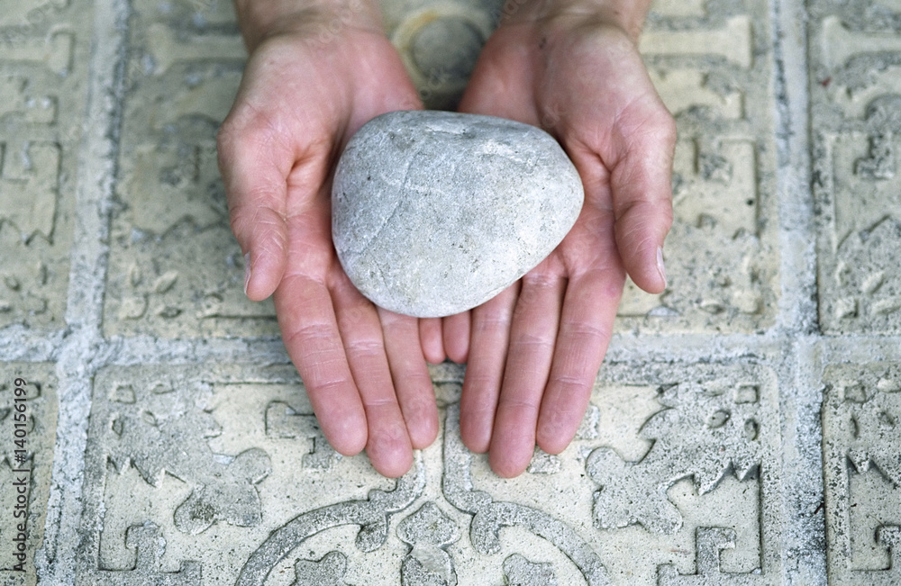 Woman holding a Stone over an ornate Ground - Meditation - Element Woman holding a Stone over an ornate Ground - Meditation - Element