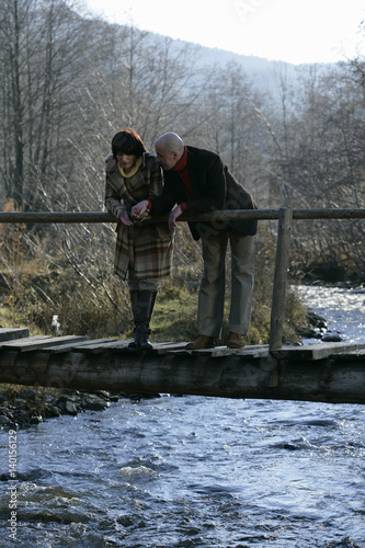 Mature couple standing on a bridge