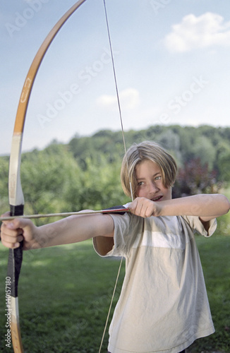 Blonde Boy targeting at something with his Bow - Archery - Weapon - Leisure Time
