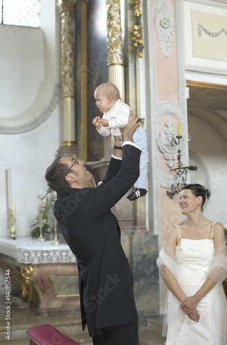 Bridegroom holding his Child into the Air - Baptism - Wedding - Church - Tradition - Christianity photo