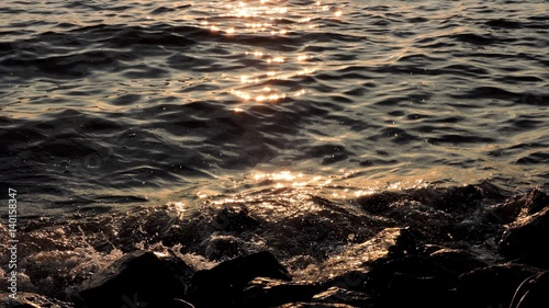 waves on rocky shore at sunset