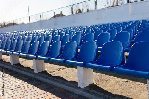 several rows of blue chairs on the stadium empty © mtrlin