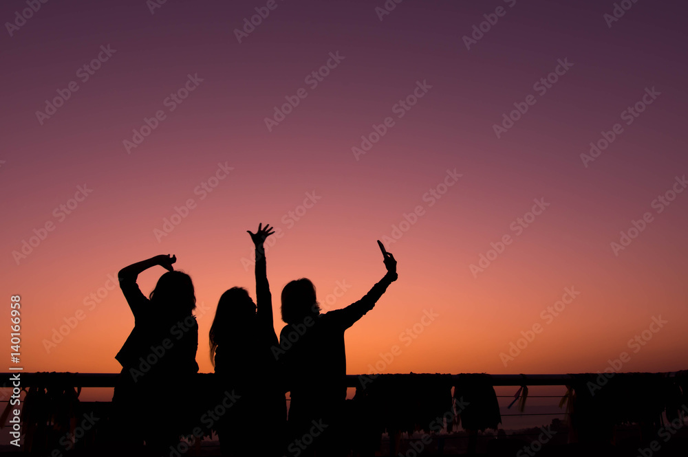 Fototapeta premium Silhouette of friend enjoying for selfie