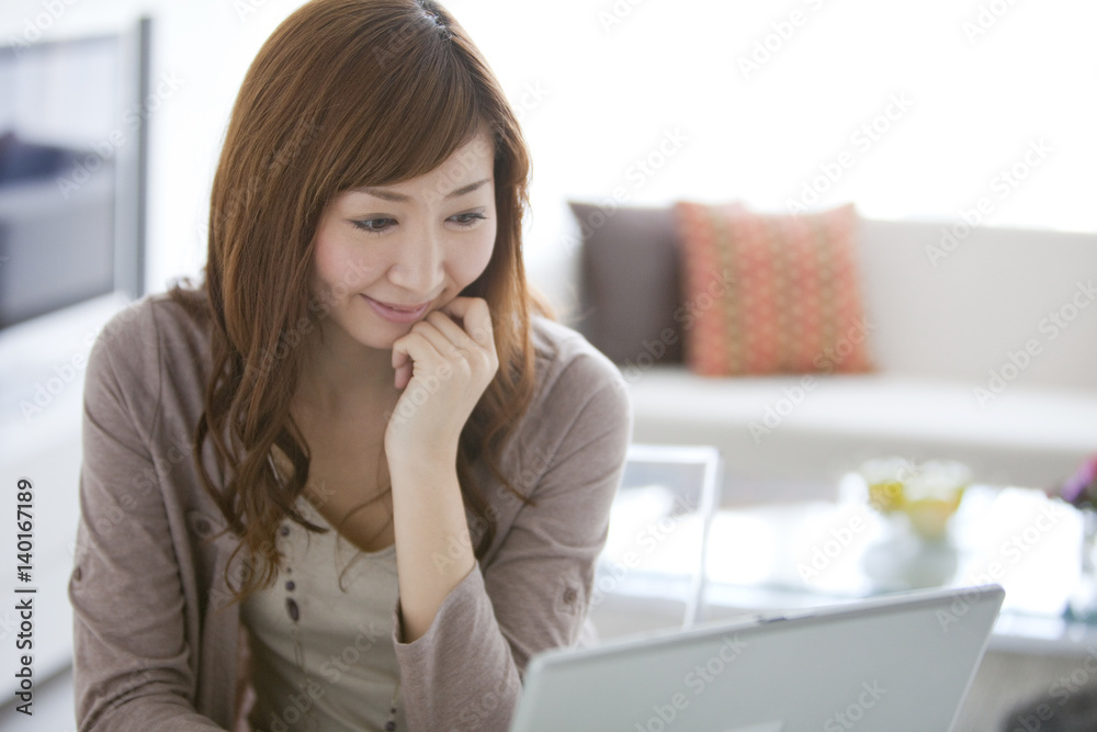 Young Woman Using Laptop in Living Room Young Woman Using Laptop in Living Room