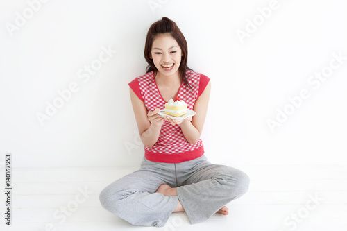 Wallpaper Mural Young woman enjoying a slice of cake Torontodigital.ca