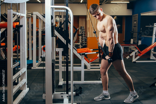 Man doing cable fly exercise in gym photo