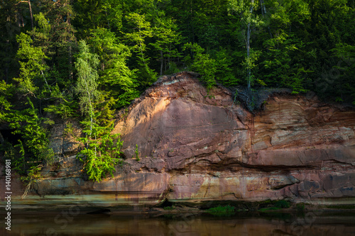 Red sandstone cliffs by the river in Gauja national park in Latvia