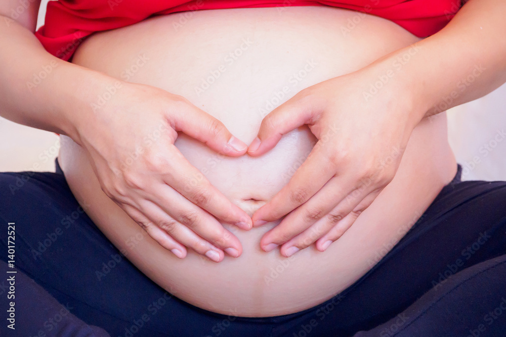 Asian pregnant woman Hands forming heart on her belly