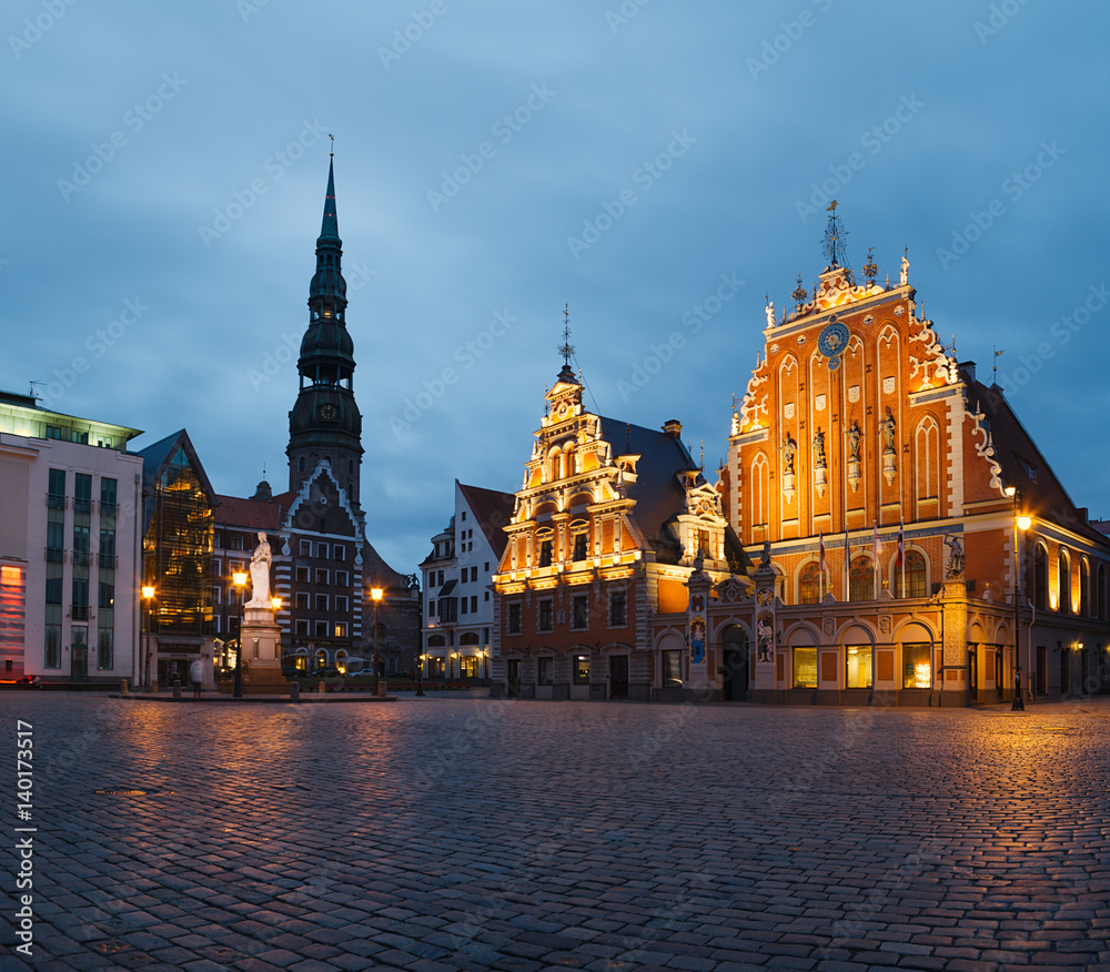 RIGA, LATVIA - 20 JUN 2016: City Hall Square with House of the Blackheads and Saint Peter church in Riga Old Town at night.