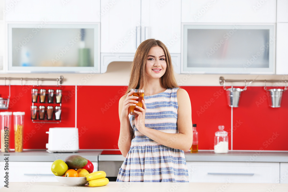 Young beautiful woman in kitchen drinking juice Young beautiful woman in kitchen drinking juice