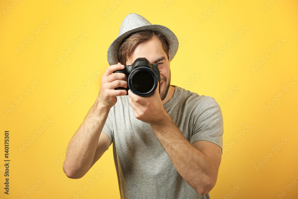 Handsome young photographer on color background Handsome young photographer on color background