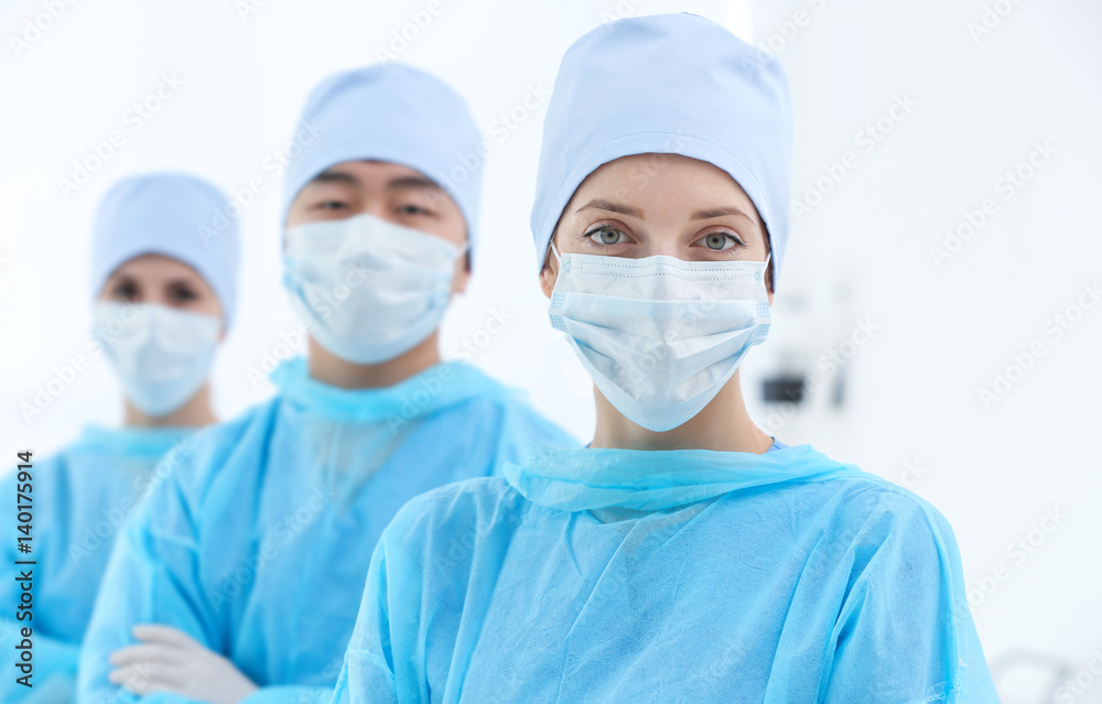 Beautiful young doctor with colleagues in clinic Beautiful young doctor with colleagues in clinic