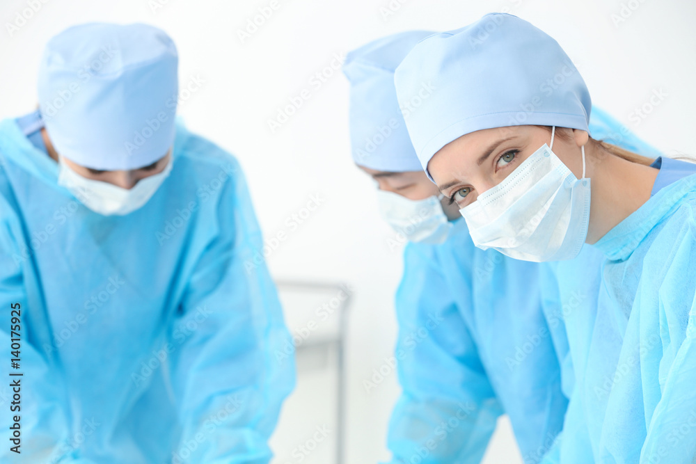 Beautiful young doctor with colleagues in clinic Beautiful young doctor with colleagues in clinic
