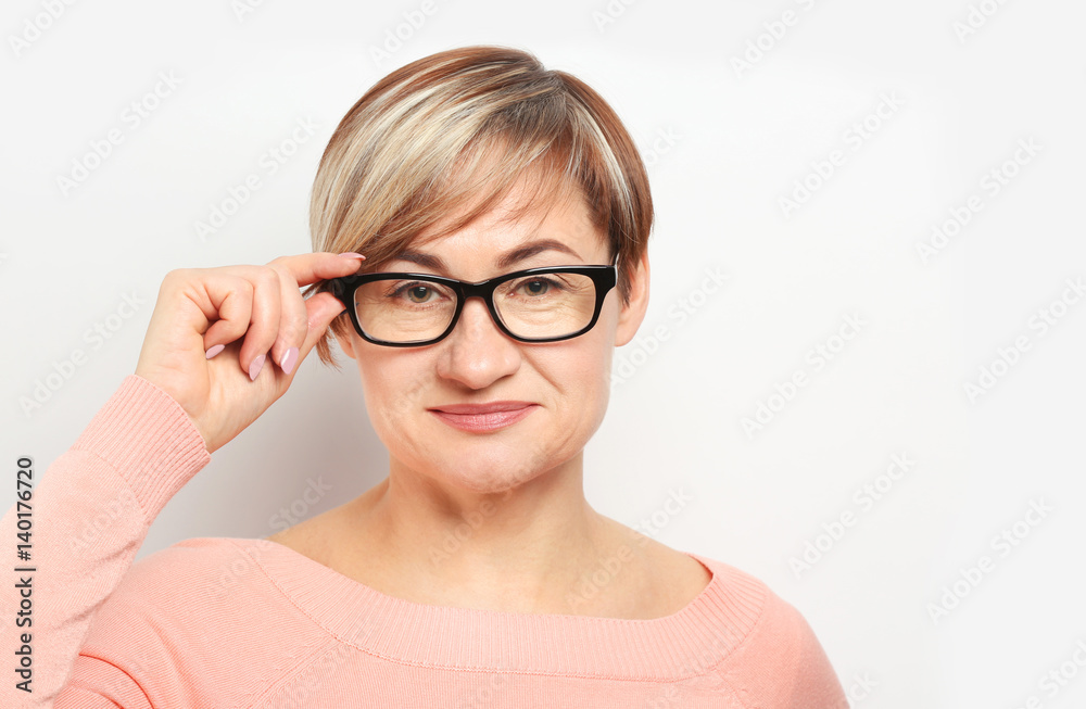 Mature woman wearing glasses on white background