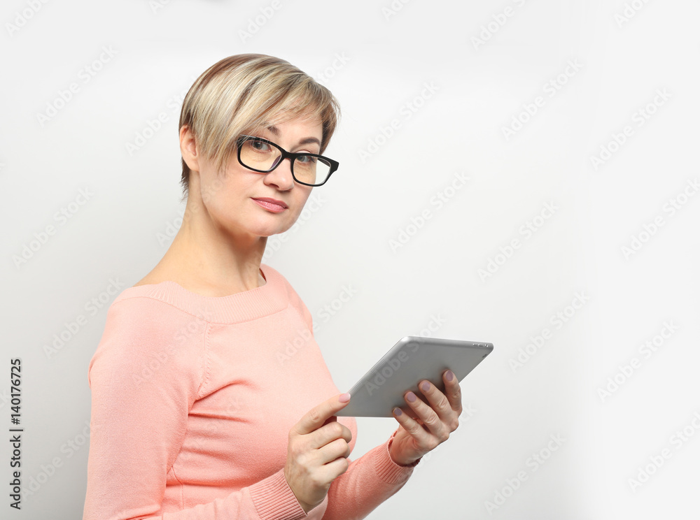 Mature woman with glasses and tablet computer on white background Mature woman with glasses and tablet computer on white background