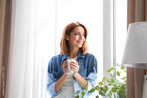 Young beautiful woman drinking tea at home