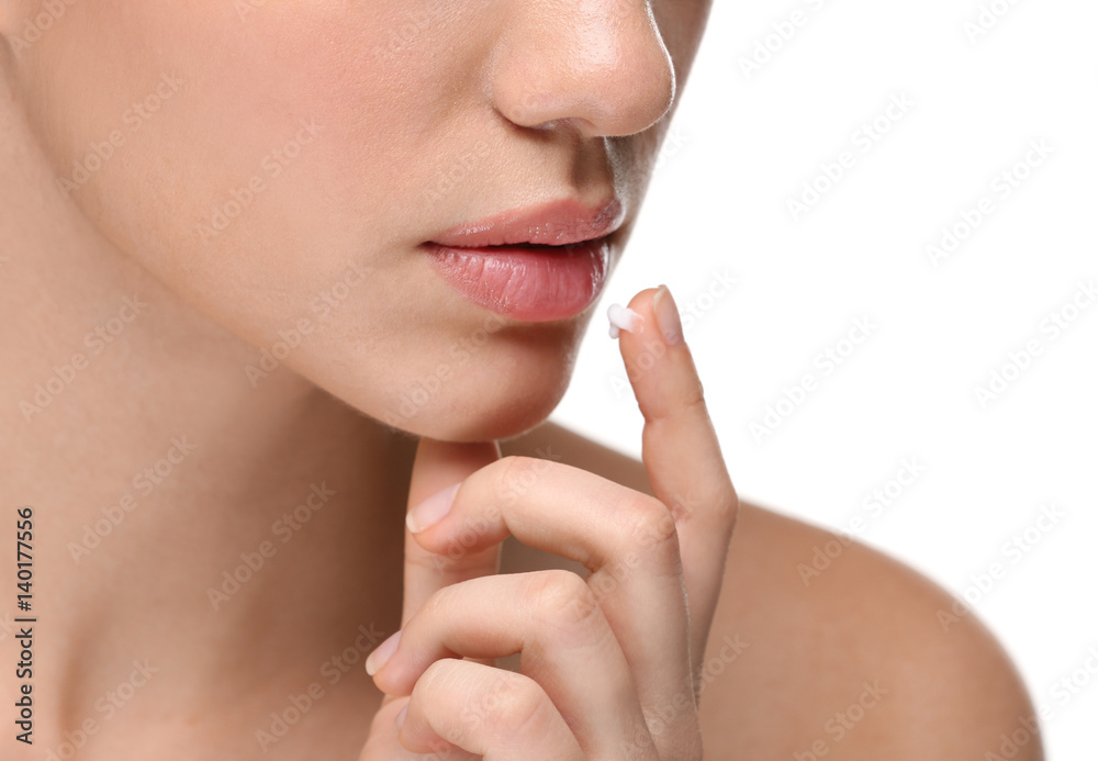 Woman applying cream onto lips on white background Woman applying cream onto lips on white background