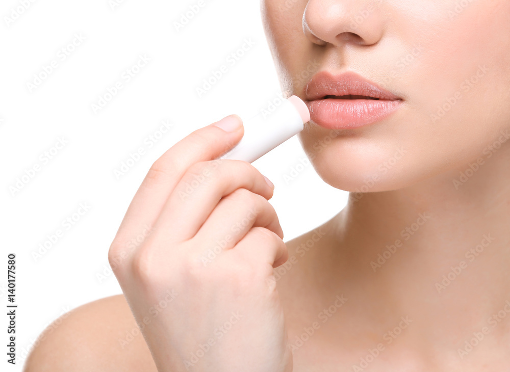 © Africa Studio - Woman applying hygienic lip balm on white background © Africa Studio - Woman applying hygienic lip balm on white background
