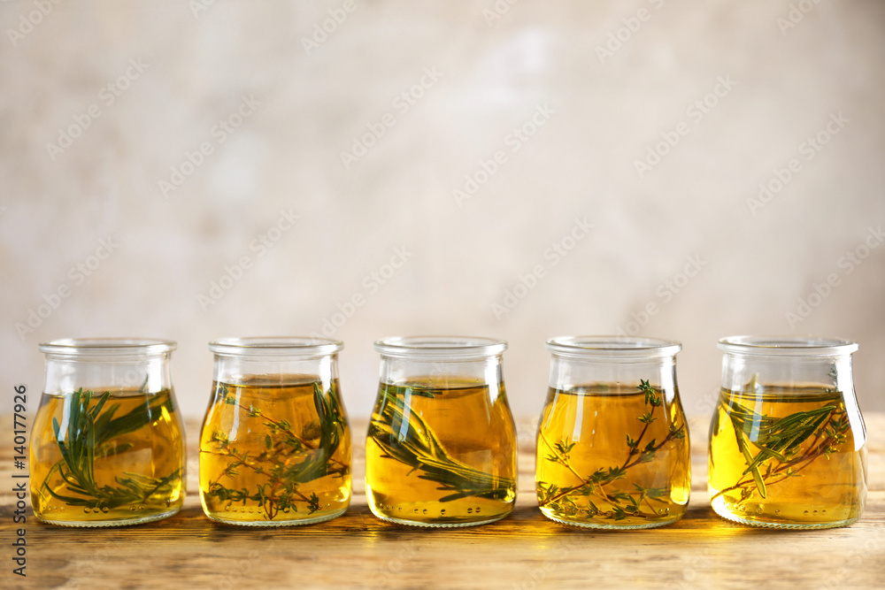Row of jars with oil on wooden table