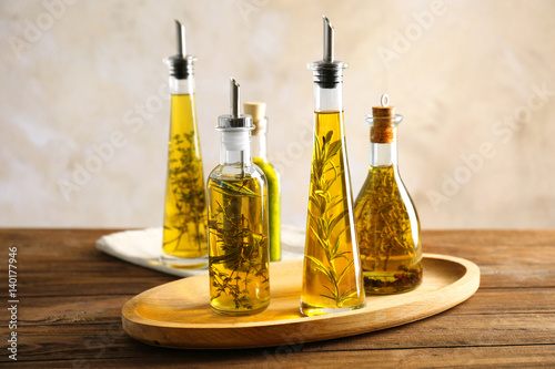 Composition of bottles with oil on wooden table