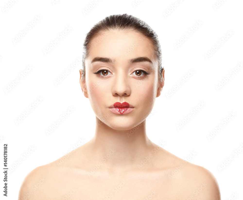 Portrait of beautiful young woman with heart painted on lips, against white background Portrait of beautiful young woman with heart painted on lips, against white background