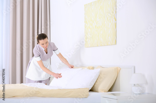 Chambermaid making bed in h...