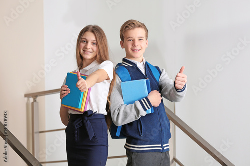 Teenagers with books standi...