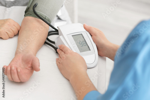 Εκτύπωση καμβά Doctor measuring pressure of elderly woman with digital sphygmomanometer while s