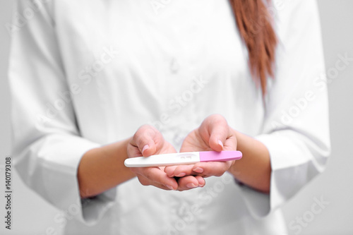 Doctor holding pregnancy test, closeup