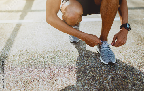Принти на полотні Running shoes, Close up of runner man trying shoelaces getting ready for run on the outdoor street