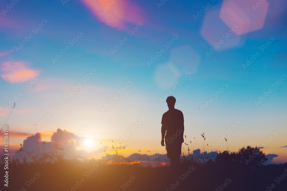 Silhouette of jumping man on sunrise background. The concept happy.
