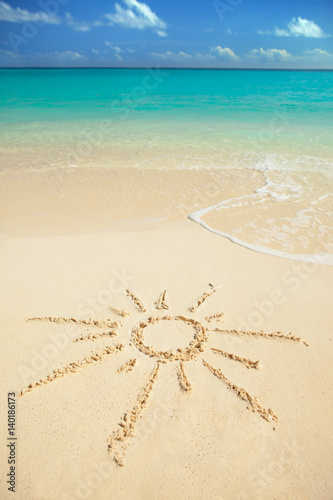 Sun drawn on sand of Tropical beach. Ocean beach background. White sand and crystal-blue sea. Ocean water nature, beach relax. Summer sea vacation. Sun protection concept