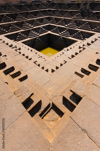 Ancient Indian Water Tank Reservoir with Steps in Hampi, India. Vertical