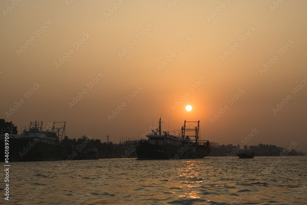 Sunset at the port with many boats in the center of Chittagong in Bangladesh
