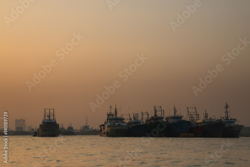 Sunset at the port with many boats in the center of Chittagong in Bangladesh 