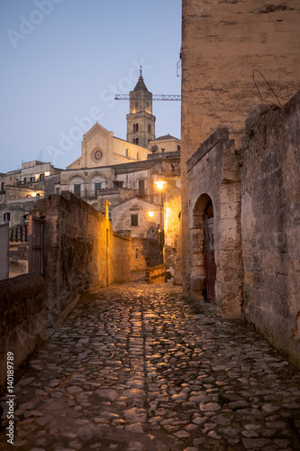 Old town of Matera. Cobble stoned alley with the Cathedral in the background