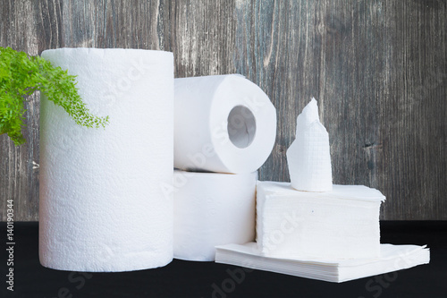 Paper tissue, paper towel and napkins on wooden background. photo