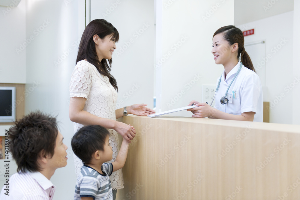 Family at reception desk in hospital, smiling Family at reception desk in hospital, smiling