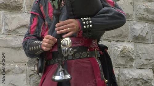 Close up of a medieval musician playing a bagpipe