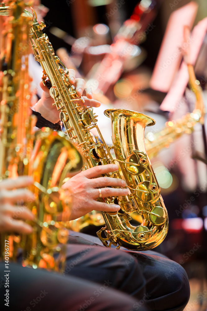 Obraz premium Saxophone in the hands of a musician in an orchestra closeup 
