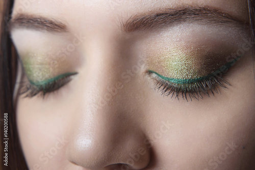 cocktail makeup closeup on closed eyes girl with clean skin. The green tones.Macro.