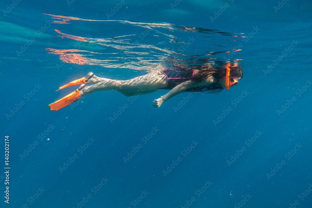 Girl in swimming mask and flippers dive in Red sea