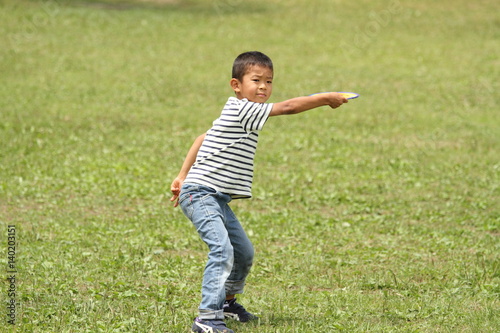Japanese boy playing flying disc (first grade at elementary school)
